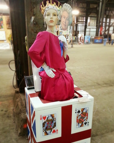 Artwork with a mannequin dressed like a queen in a clothes washing machine