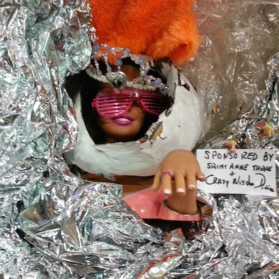 sculpture of woman's head and hand surrounded by silver foil