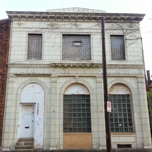 Terra cotta facade storefront in Pittsburgh with the engraved names Lackzoom and Acidophilus