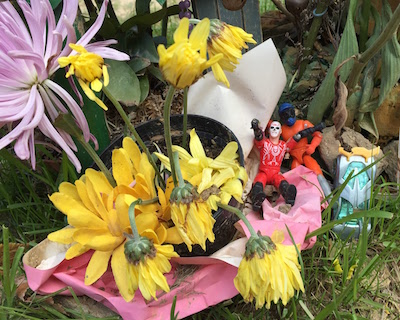 two plastic action figures with living flowers