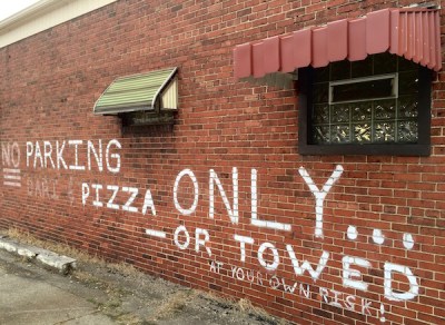 Painting on brick wall of pizza restaurant reading "NO Parking Pizza Only ... -- or Towed at your own risk!", Homestead, PA