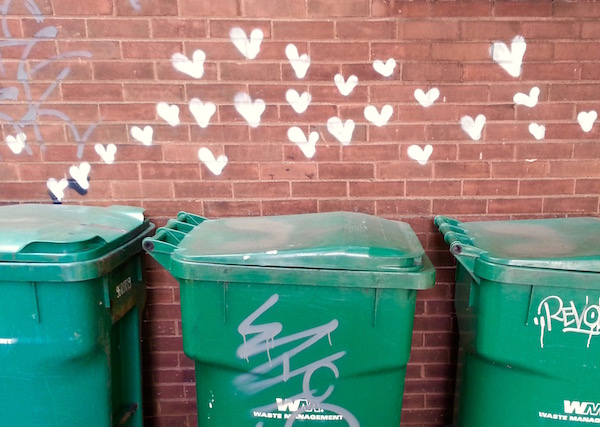 graffiti on brick wall of dozens of small hearts above a row of commercial trash bins, Pittsburgh, PA