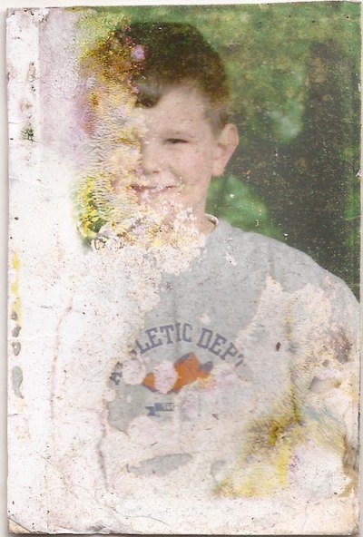 water-damaged wallet size photograph of an unknown boy