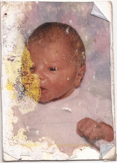 water-damaged wallet size photograph of an unknown baby