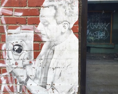 image of man with camera wheatpasted to brick wall, Pittsburgh, PA