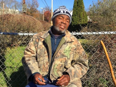 Man in winter clothes against chain link fence, Pittsburgh, PA