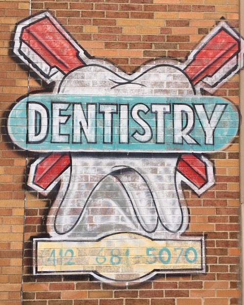 mural on brick wall of large tooth with crossed toothbrushes and the sign "Dentistry", Pittsburgh, PA