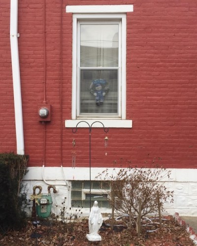 statuette of Mary by red brick rowhouse, Pittsburgh, PA