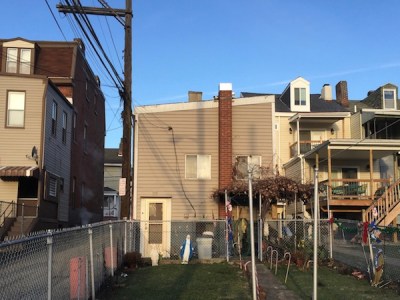 two statuettes of Mary in a row house backyard, Pittsburgh, PA