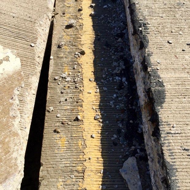 detail of broken road sections showing painted yellow line, Harmar, PA