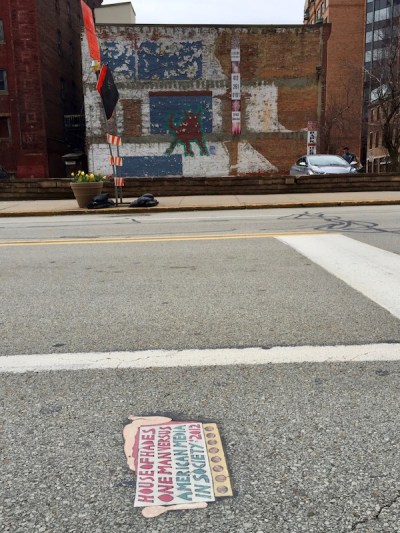 street art "Toynbee tile" and buildings of downtown Pittsburgh, PA