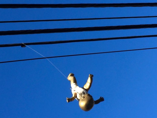 baby doll painted gold and hanging from telephone wires, Pittsburgh, PA