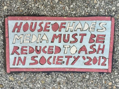 Street art "Toynbee tile" reading "House of Hades, media must be reduced to ash in society: 2012", Pittsburgh, PA