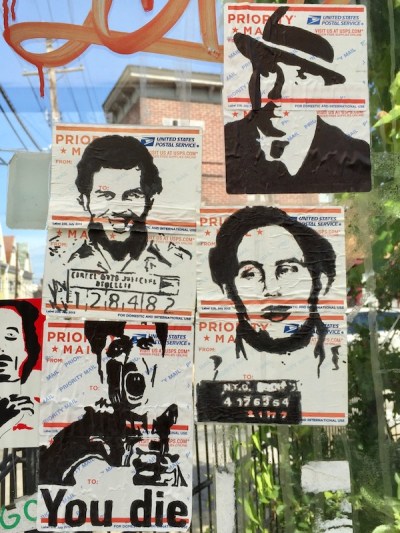 portraits of criminals drawn on US postal service mail label and stuck to glass bus shelter, Pittsburgh, PA