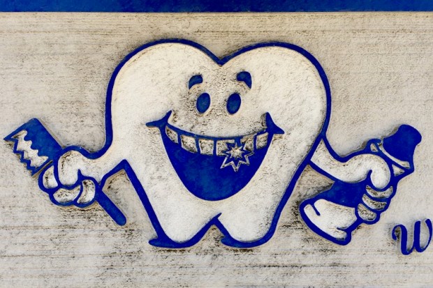 anthropomorphized smiling tooth with toothbrush and toothpaste from a sign for McKees Rocks Dental, McKees Rocks, PA