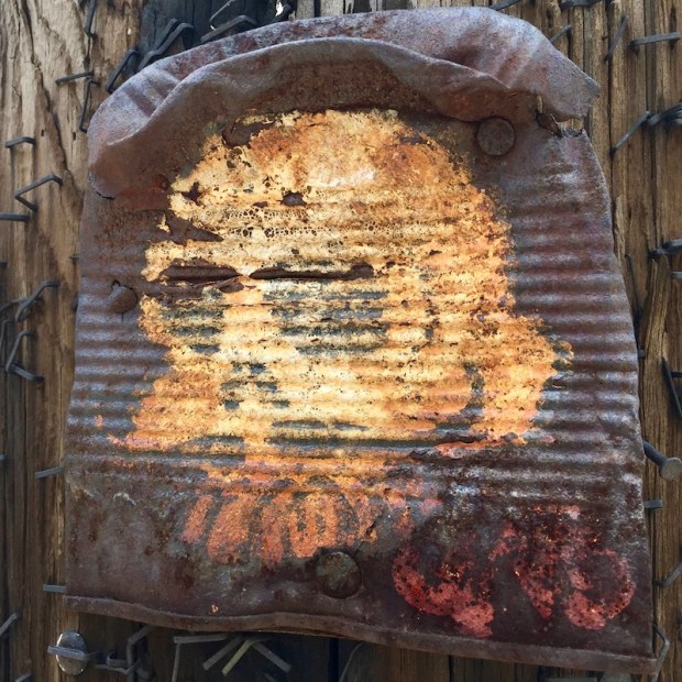 rusted tin can with painting of a skull, nailed to telephone pole, Pittsburgh, PA