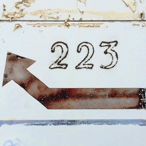 tile building facade with number 223 and arrow directing around the back, Homestead, PA