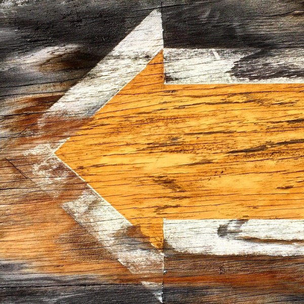 yellow arrow painted on weathered plywood, Pittsburgh, PA