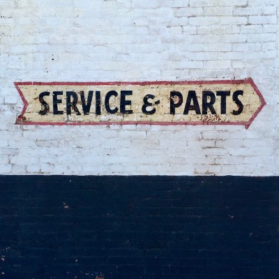 "Service & Parts" sign painted in shape of an arrow on brick wall, Pittsburgh, PA