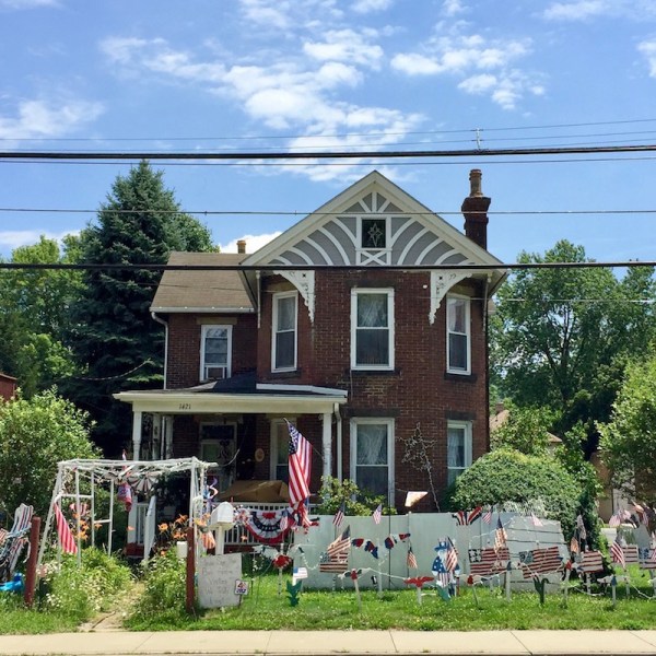 brick house with many handmade wood cut Independence Day lawn decorations, Beaver, PA