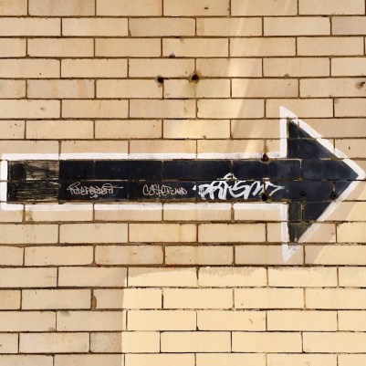 arrow painted on white brick wall, Pittsburgh, PA