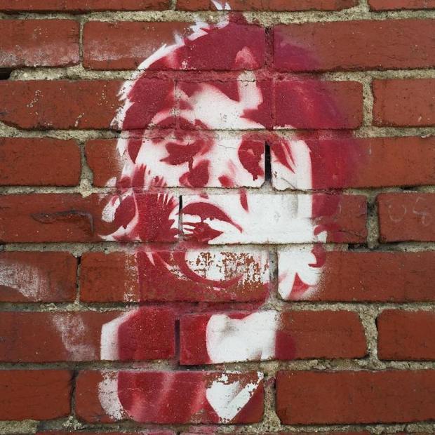 stencil image of man's face painted on brick wall, Pittsburgh, PA