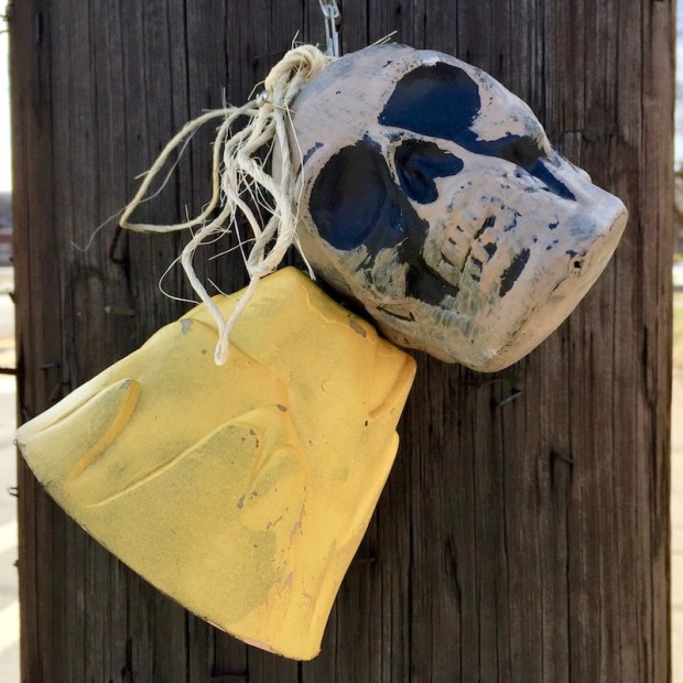 skull and bell attached to utility pole