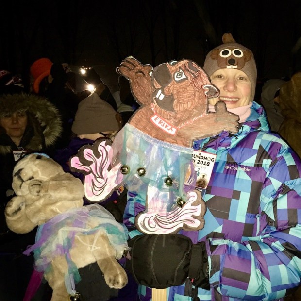 woman holding groundhog cutout labeled "Erika"