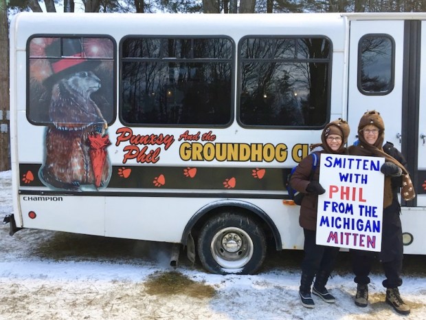 two women holding a sign reading "Smitten with Phil from the Michigan mitten" at Groundhog Day