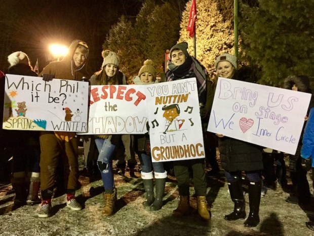five young people with homemade signs for Groundhog Day.