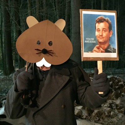 man with groundhog mask and Bill Murray hand sign