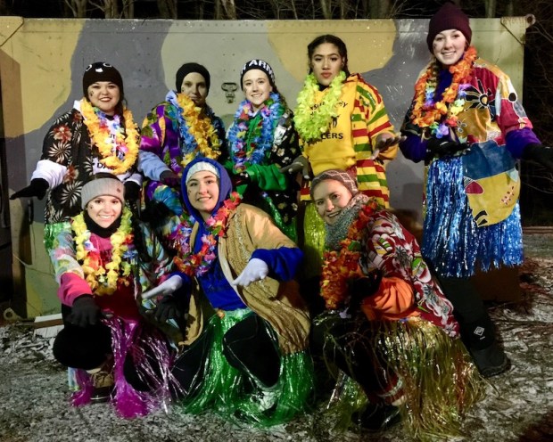Women dressed in colorful Hawaiian shirts, skirts, and leis for Groundhog Day party