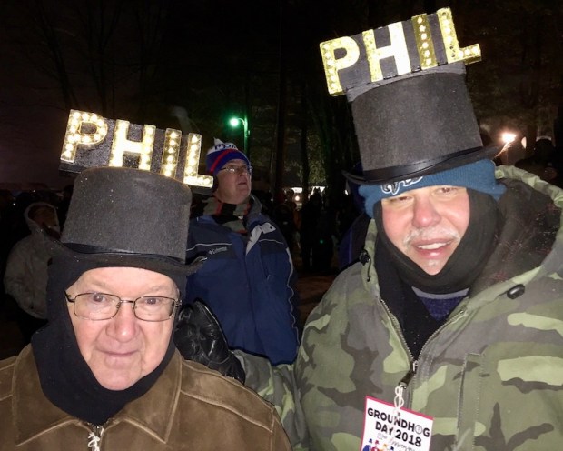 two men wearing novelty top hats with light-up "PHIL" letters for Groundhog Day