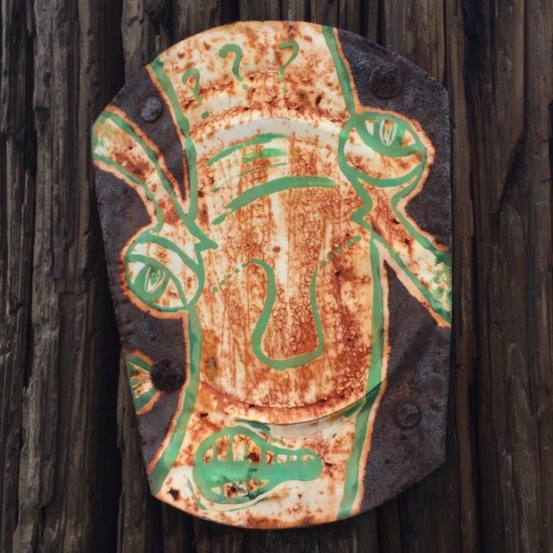 tin can lid painted with abstract face and nailed to telephone pole, Pittsburgh, PA
