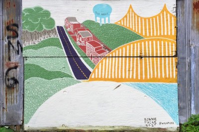 garage door covered with plywood painted with colorful bridge and hills, Pittsburgh, PA