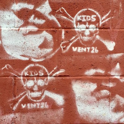 graffiti stencils of skull and crossbones and pig heads on cinderblock wall, Pittsburgh, PA