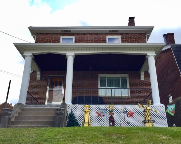 decorative model lighthouses painted black-and-gold in front yard of house in Whitaker, PA