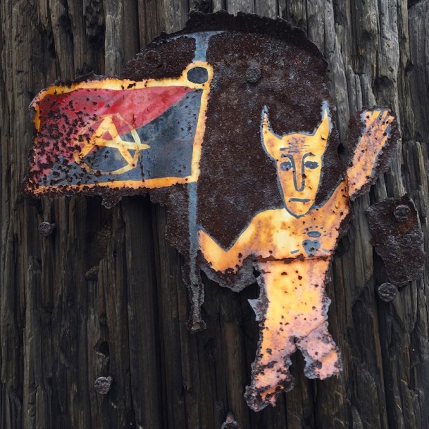 metal can lid painted with devil holding anarchy flag nailed to utility pole, Pittsburgh, PA