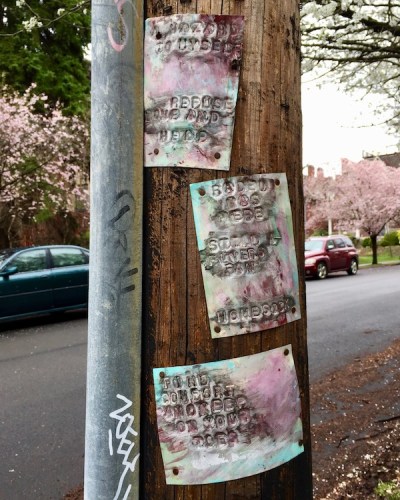 metal sheets stamped with words and painted, nailed to utility pole in Pittsburgh, PA