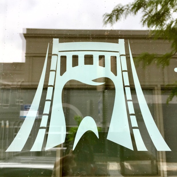 logo for Merit Dental of a combined bridge and tooth