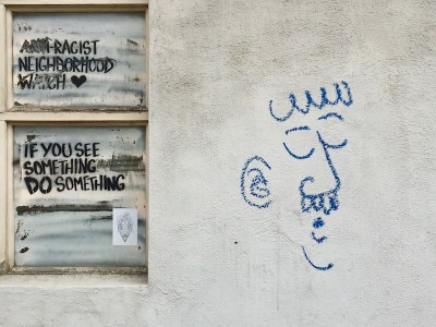 graffiti drawing of man with mustache on white stucco wall