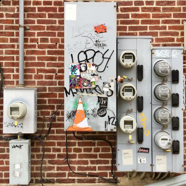 wheatpaste traffic cone with eyeballs on electric panel