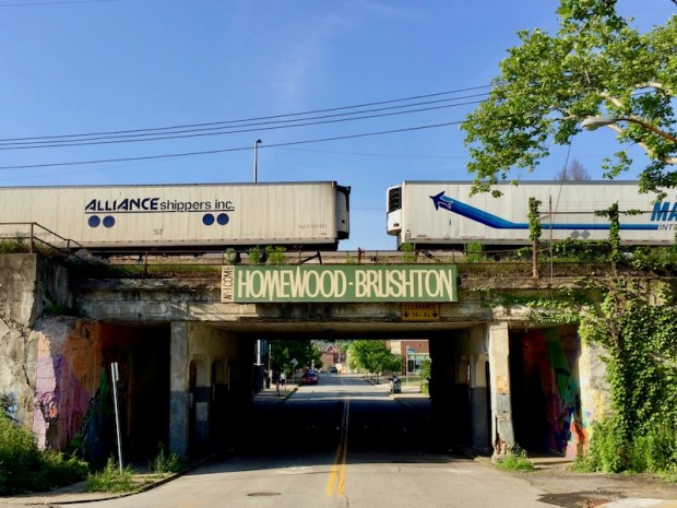 neighborhood welcome sign for Homewood-Brushton, Pittsburgh on train track overpass