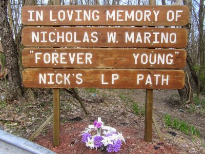 roadside memorial made from inscribed wooden planks
