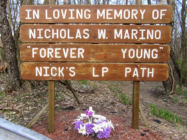 roadside memorial made from inscribed wooden planks