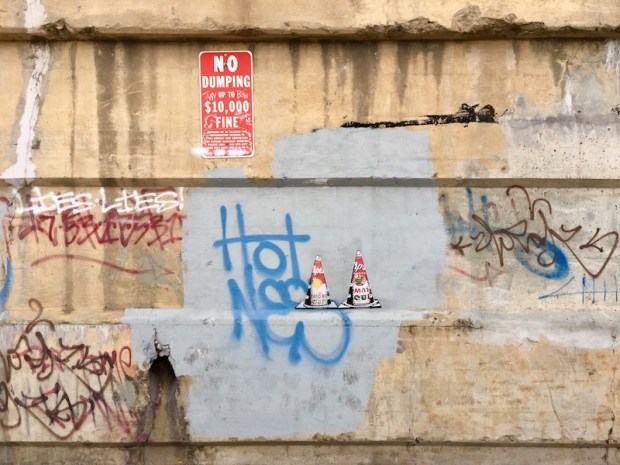 wheatpaste images of traffic cones with eyeballs on cement wall, Pittsburgh, PA