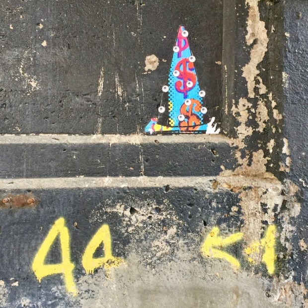 wheatpaste traffic cone with eyeballs on concrete wall, Pittsburgh, PA