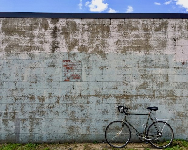 10-speed bicycle leans against a weathered cinderblock wall, Clairton, PA