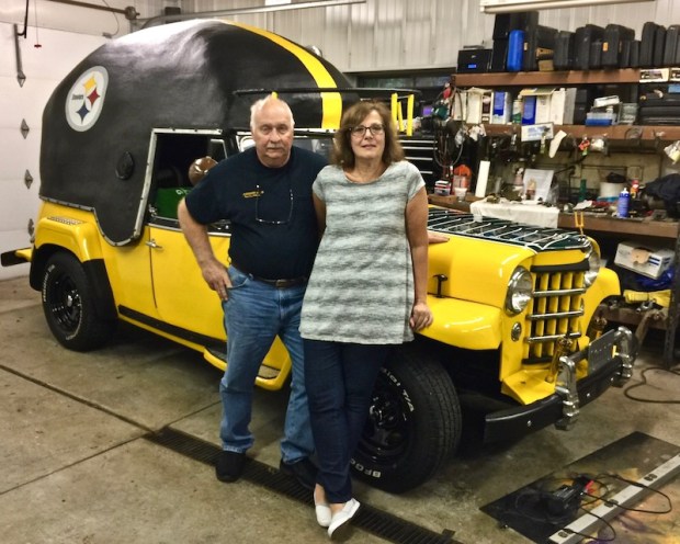 Ray and Kathi Kasunick in front of their 1950s era Willy's Jeepster painted in tribute to the Pittsburgh Steelers
