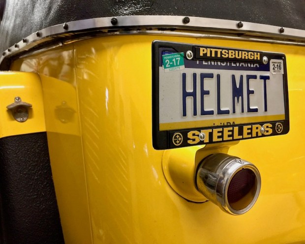 detail of 1950s era Willy's Jeepster showing "HELMET" personalized license plate and mounted bottle opener